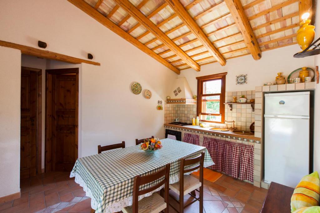 a kitchen with a table and a kitchen with a refrigerator at case vacanza zingaro in San Vito lo Capo