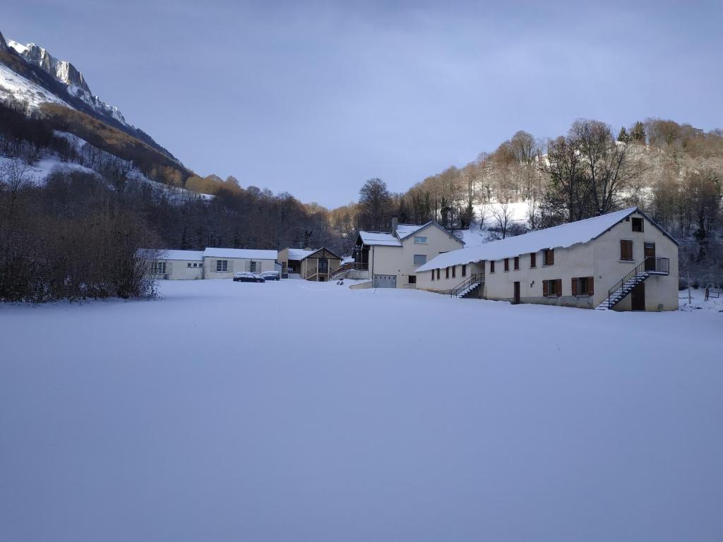 um grupo de edifícios numa cidade coberta de neve em Centre de vacances La Salamandre em Arrens-Marsous