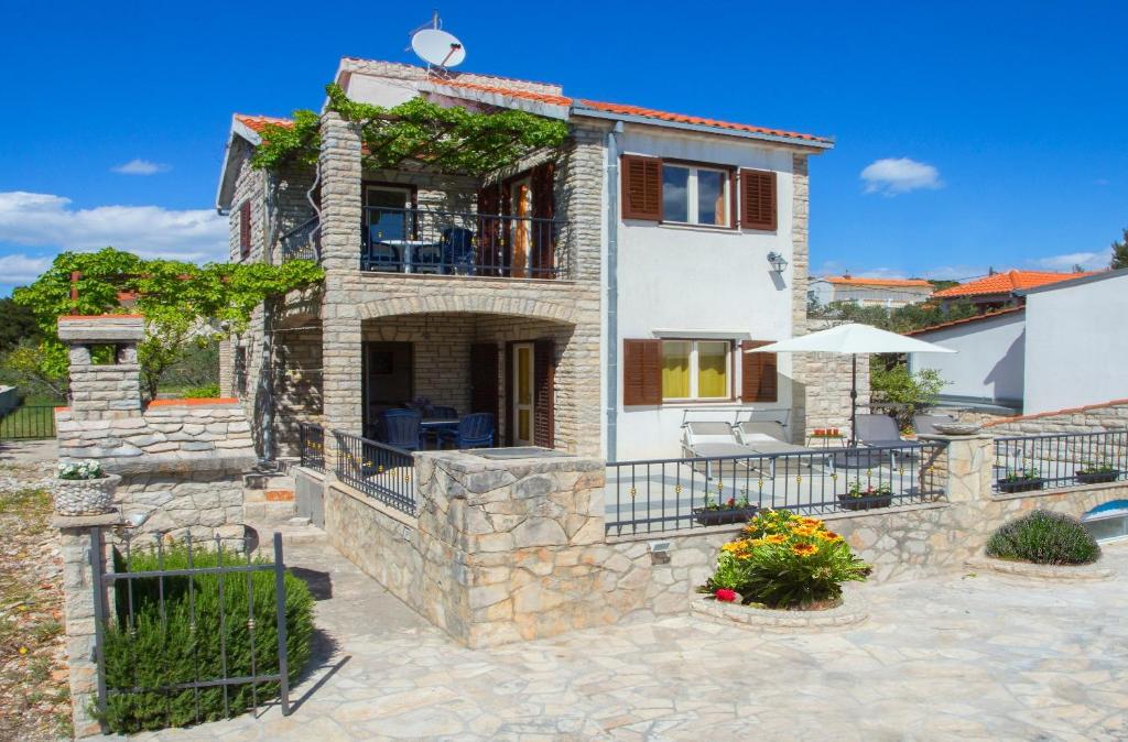 eine Villa mit einer Steinfassade und einer Terrasse in der Unterkunft Apartments Ana - quiet and peaceful in Maslinica