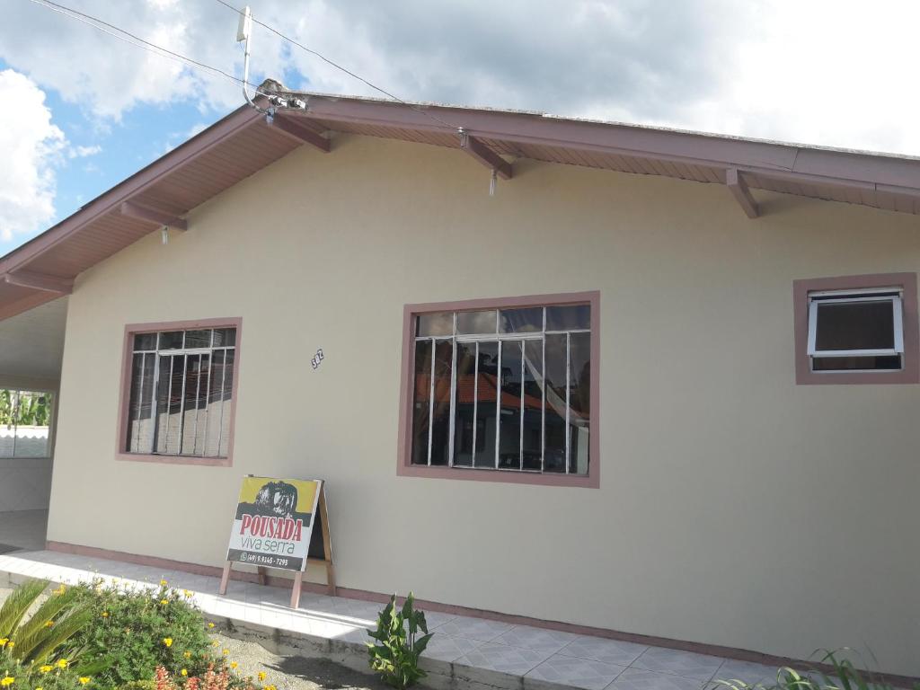 una casa blanca con un cartel delante en Pousada Viva Serra, en Urubici