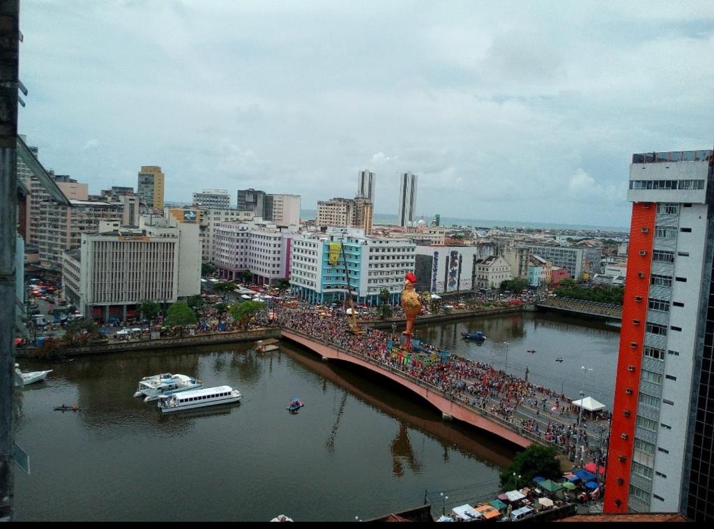 a bridge over a river in a city with buildings at Recife Centro Apartamento in Recife