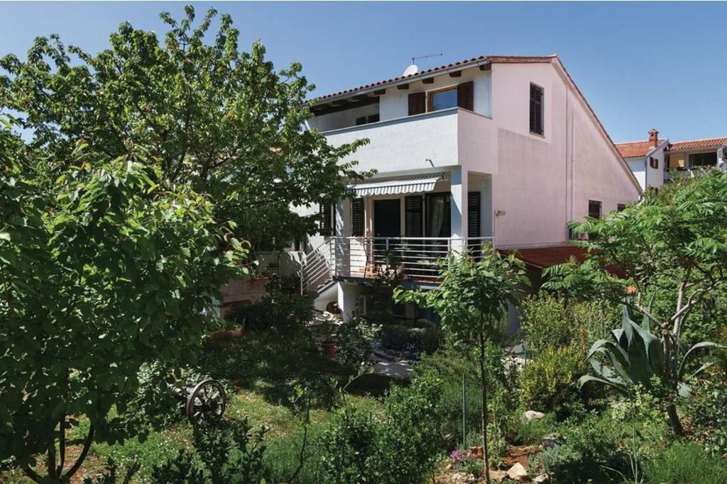 ein Haus inmitten eines Gartens mit Bäumen in der Unterkunft Apartment Rosa 1 (AP-A4) in Rovinj
