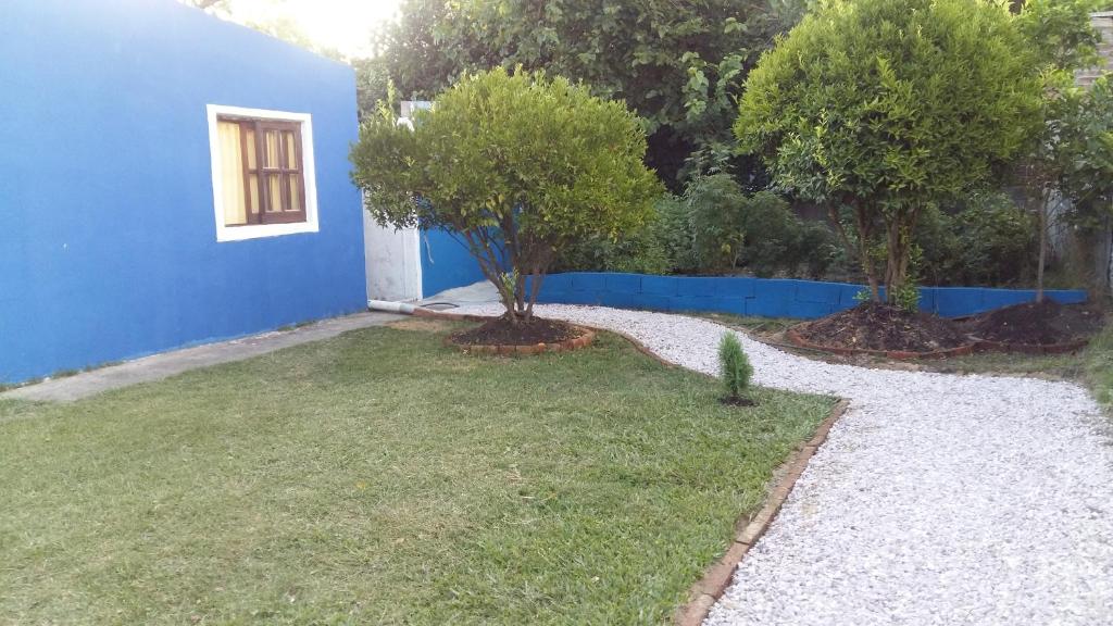 un patio con una casa azul y un árbol en Munaywasy monoambiente para dos, en Piriápolis