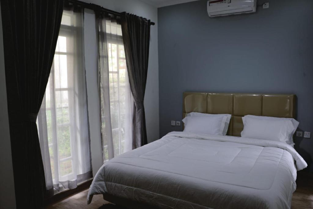 Postel nebo postele na pokoji v ubytování Diyar Villas Puncak M6-11