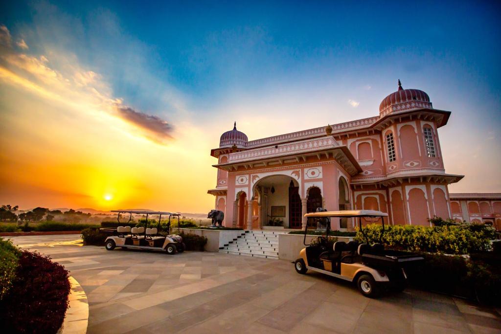 a building with two golf carts parked in front of it at Buena Vista Luxury Garden Spa Resort in Jaipur