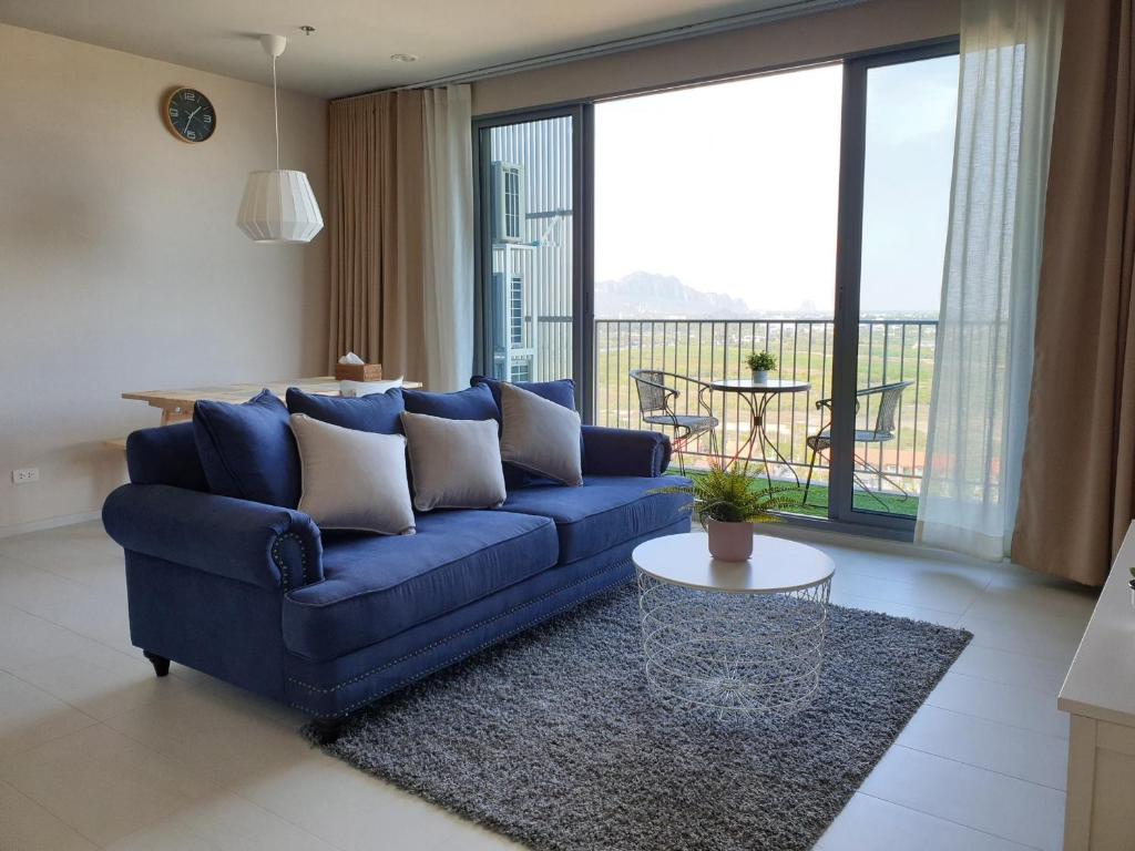 Blu Condo (Chaam - Huahin) في تشا أم: غرفة معيشة مع أريكة زرقاء وطاولة