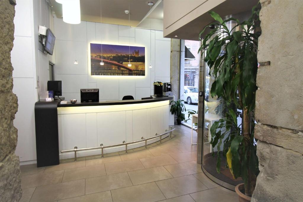 a lobby with a reception desk and a potted plant at Best Western Lyon Saint-Antoine in Lyon