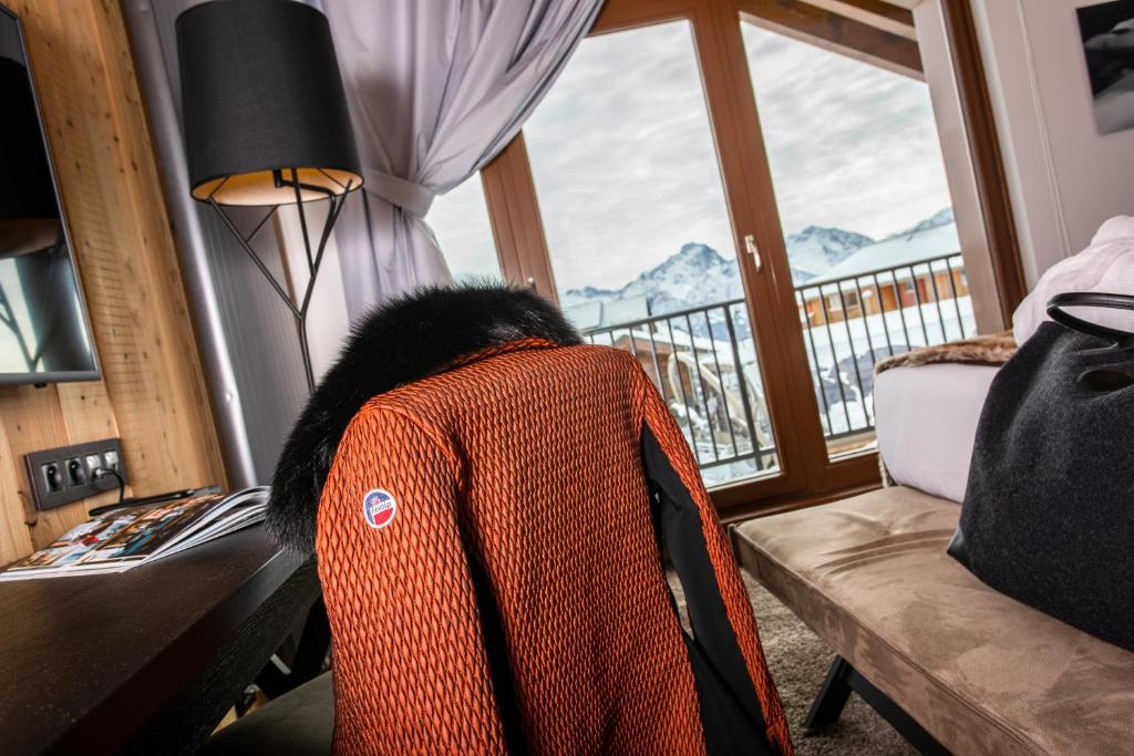 a jacket sitting on a desk in front of a window at Hôtel Daria-I Nor by Les Etincelles in L'Alpe-d'Huez