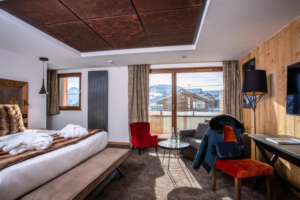 a hotel room with a bed and a couch at Hôtel Daria-I Nor by Les Etincelles in L'Alpe-d'Huez