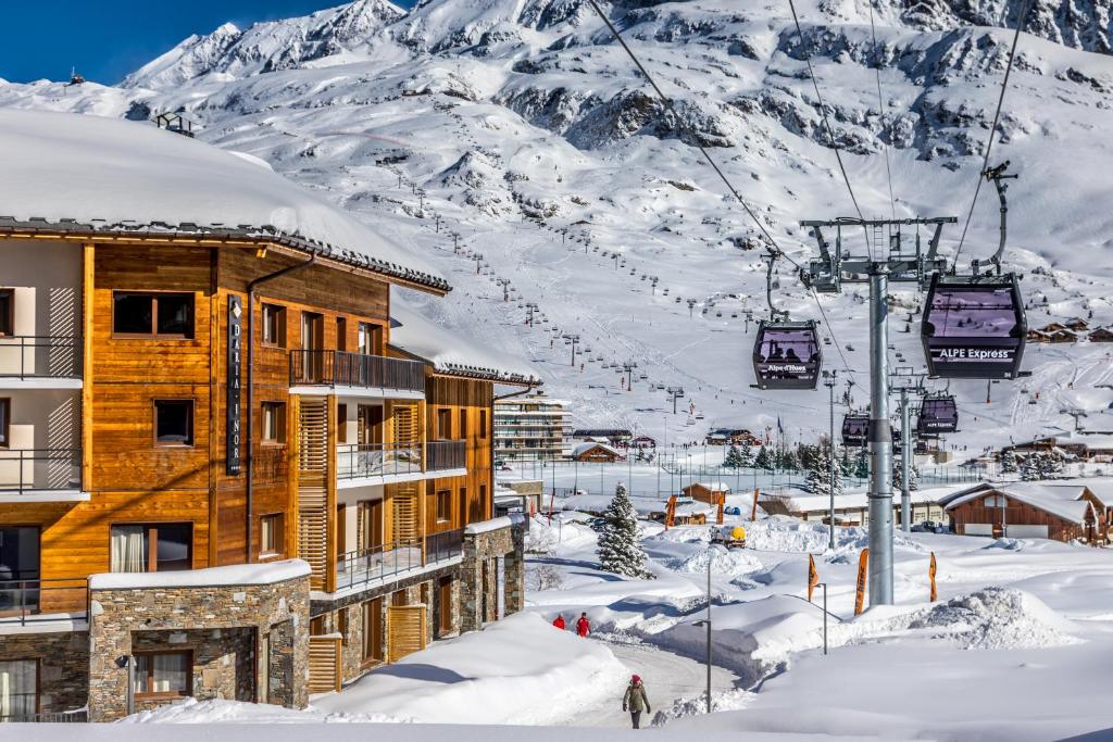 a ski lodge in the snow with a ski lift at Hôtel Daria-I Nor by Les Etincelles in L'Alpe-d'Huez