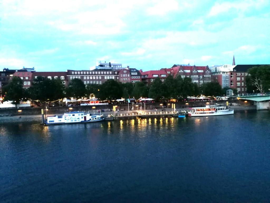 a group of boats docked in a river with buildings at Fernblick in Bremen