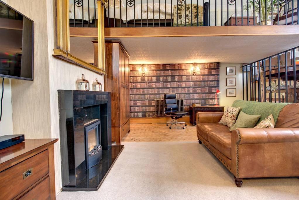 a living room with a couch and a fireplace at Carnegie Library: Bronte Apartment 1 bedroom in Swinton