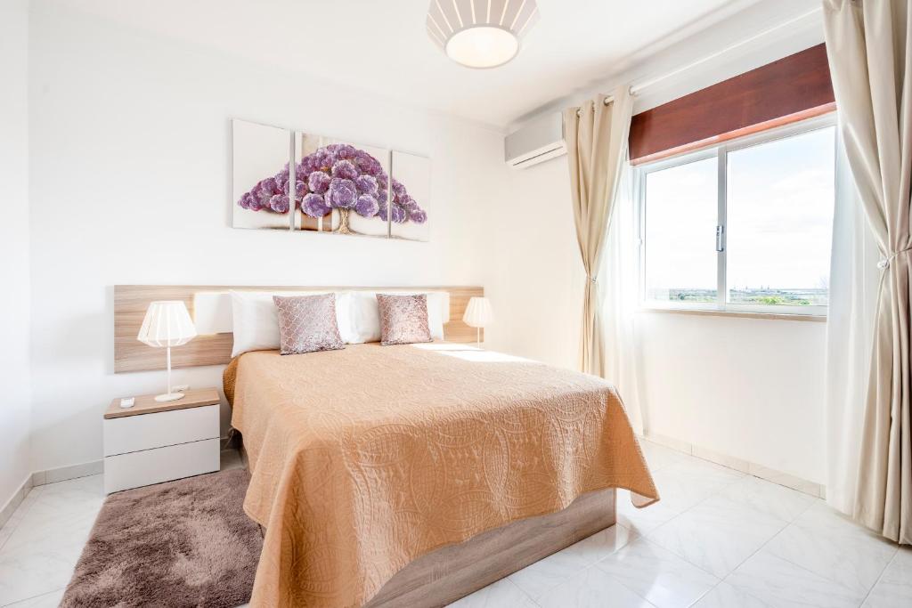 a white bedroom with a bed and a window at My Place @ Faro Ria Views in Faro