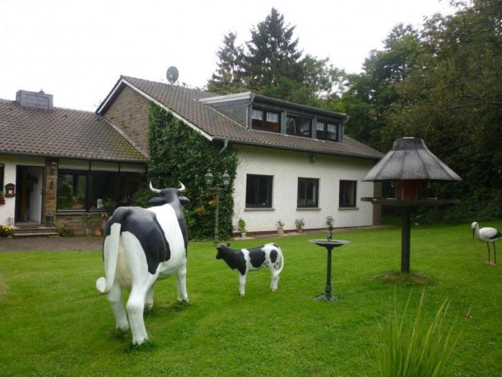 eine Statue einer Kuh und eines Kalbs auf einem Hof in der Unterkunft Land des Friedens in Nettersheim / Eifel in Nettersheim