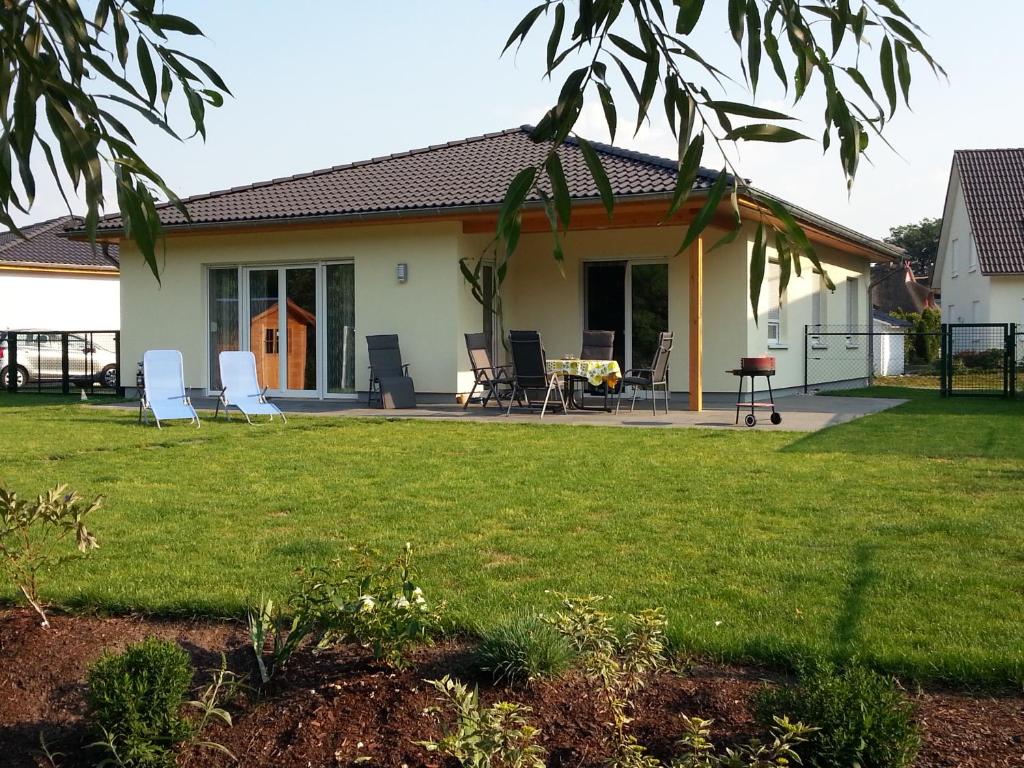 een huis met stoelen en een tuin bij Ferienhaus Scharmützelsee in Wendisch Rietz