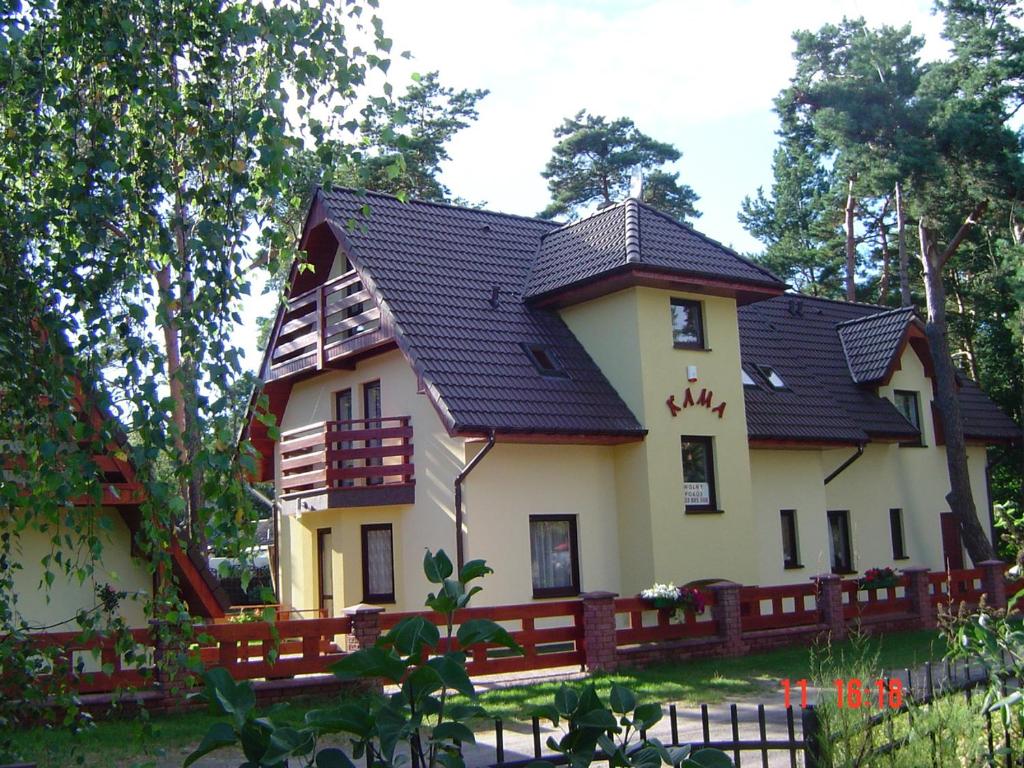 a large house with a black roof at Kama Pobierowo in Pobierowo