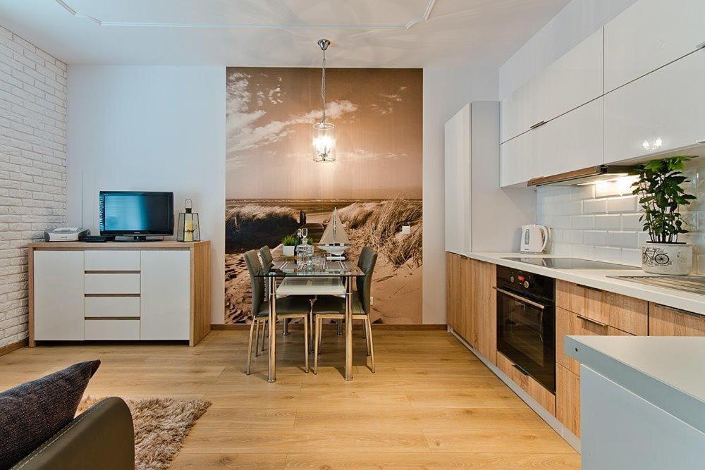 a kitchen with a table and a dining room at Dream Apartments- Balticana in Sopot