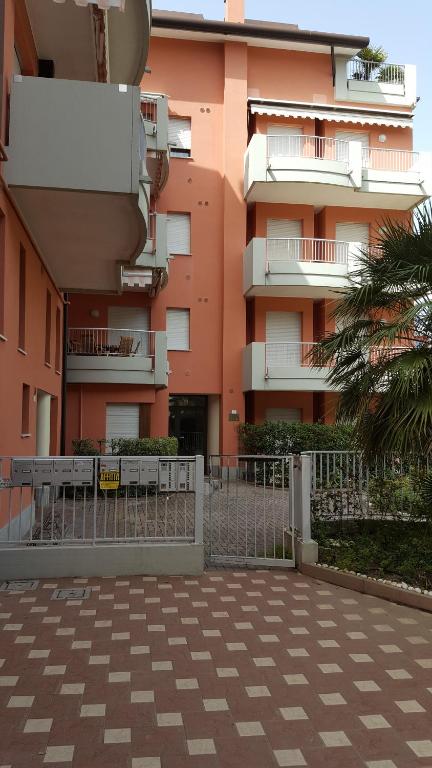 een roze gebouw met een hek ervoor bij RESIDENCE IPANEMA - WALTERIGATO Apartments SOLO PER FAMIGLIE in Lido di Jesolo