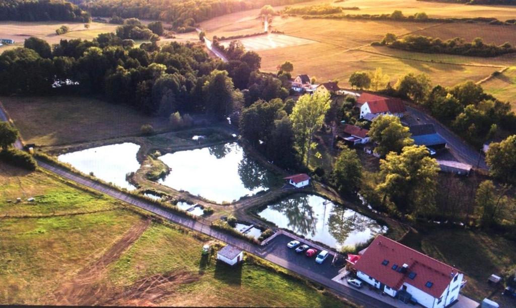 una vista aerea di un parco con un ponte sul lago di Dorf Alm Ferienwohnung a Schwalmtal