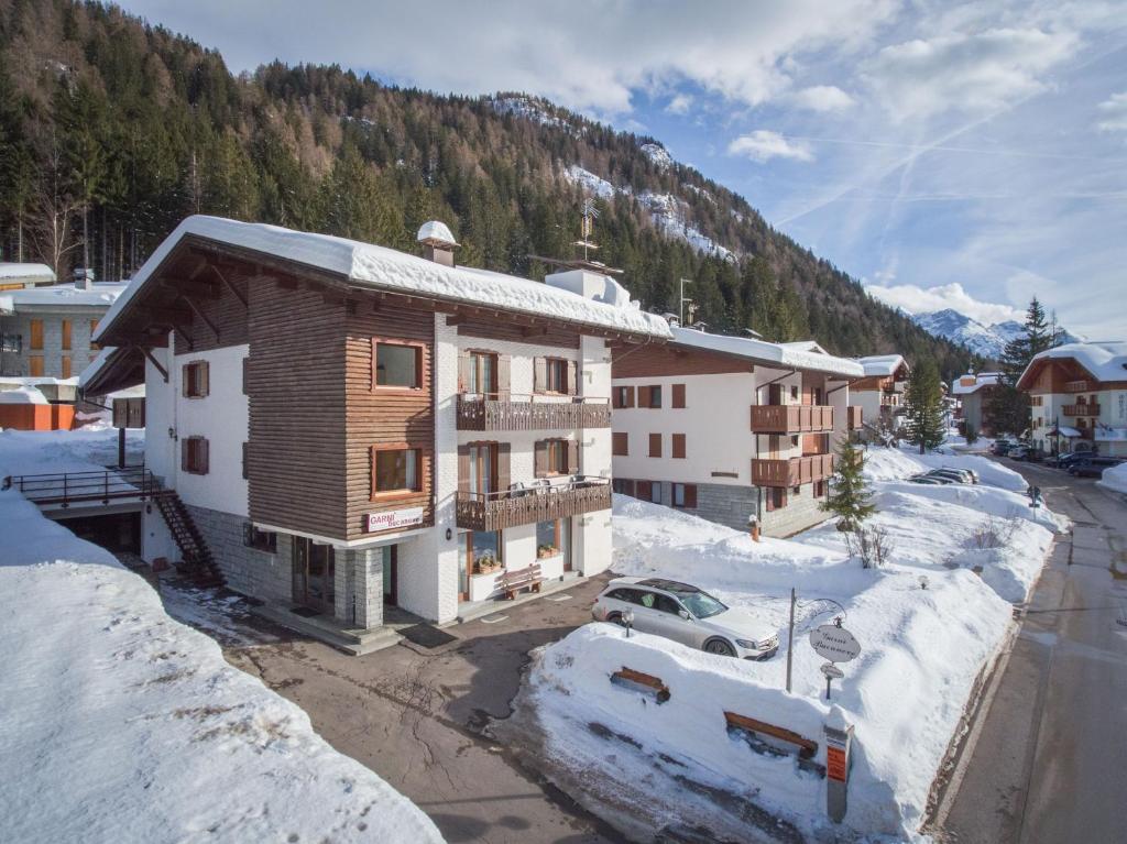 a building in a town with snow on the ground at Garnì BUCANEVE Bed & Breakfast in Madonna di Campiglio