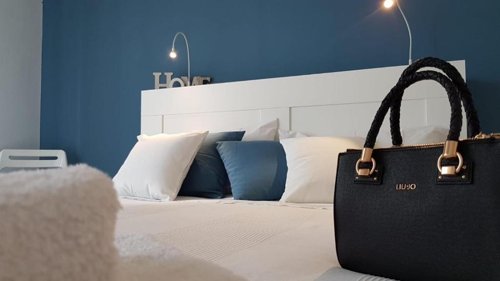 un sac noir assis au-dessus d'un lit dans l'établissement Vista sullo stretto, à Reggio de Calabre