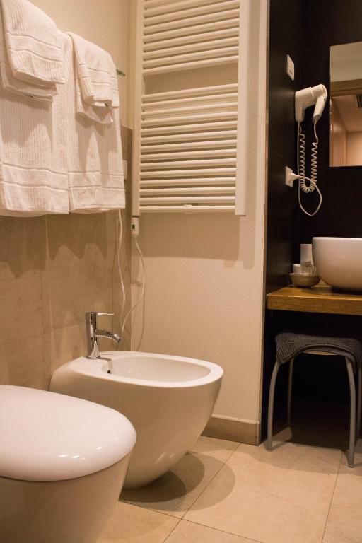 Łazienka z białą toaletą i umywalką w obiekcie Le Querce Hotel w mieście Salsomaggiore Terme