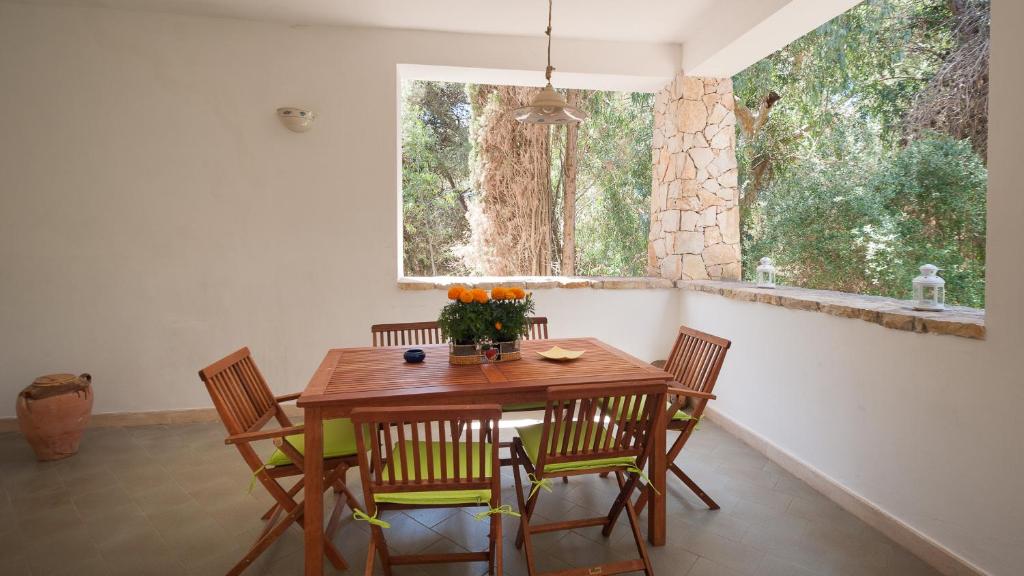 comedor con mesa, sillas y ventana en Dependance Santa Caterina - Nardò, en Santa Caterina di Nardò