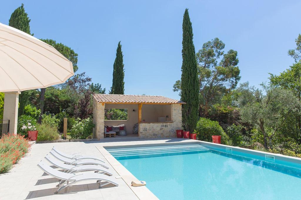 una piscina con sillas y una casa en Gite des Alexandrins, en Uzès