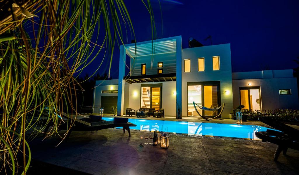 a house with a swimming pool at night at Filerimos Oasis Luxury Villa in Ialysos