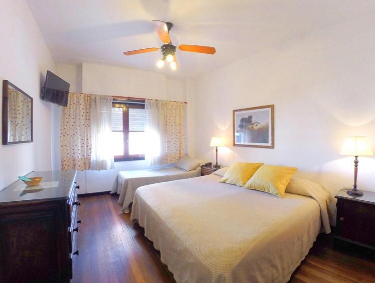 a bedroom with two beds and a ceiling fan at Hotel Imperio in Mar del Plata
