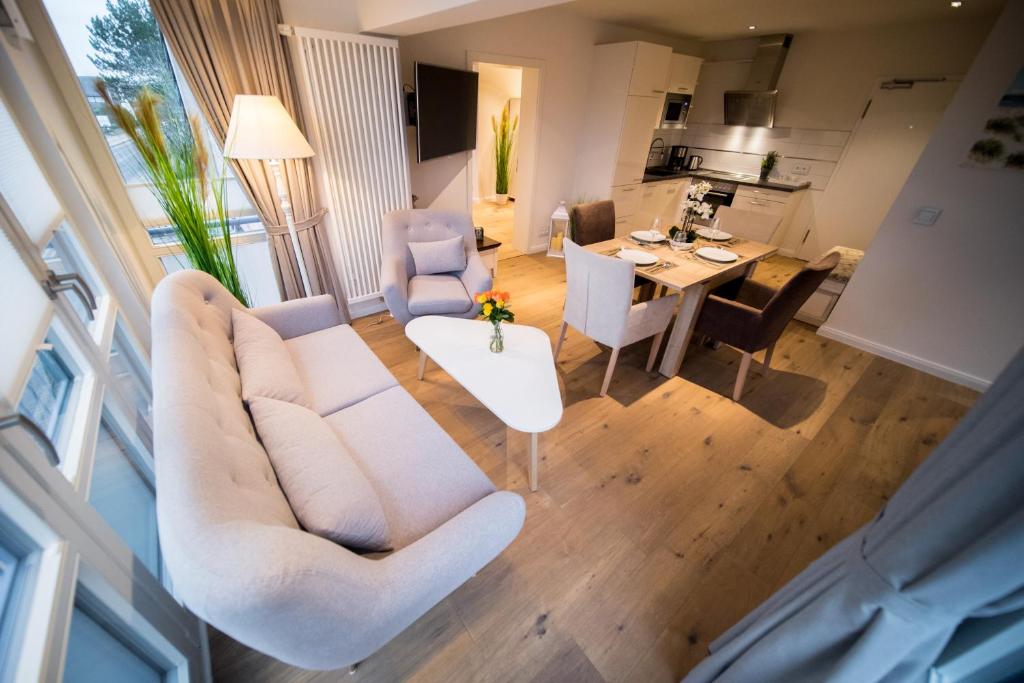 a living room with a couch and chairs and a table at Lichtmeer in Westerland (Sylt)