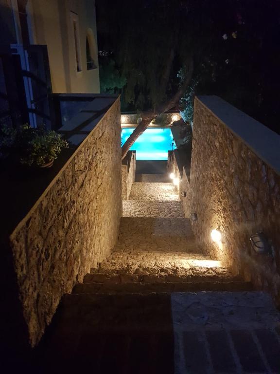 a set of stairs leading to a pool at night at PLEIADES lUXURY APARTMENTS in Porto Heli