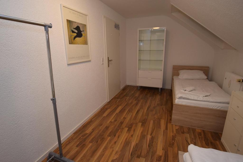 Apartment Ostfildern-Nellingen II في اوستفيلدن: غرفة صغيرة بسريرين وأرضيات خشبية