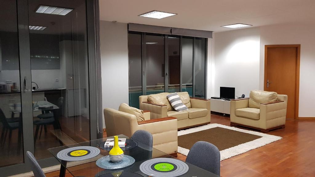 ein Wohnzimmer mit Sofas, Stühlen und einem Tisch in der Unterkunft VRS - Boavista Casa Da Musica Flats in Porto