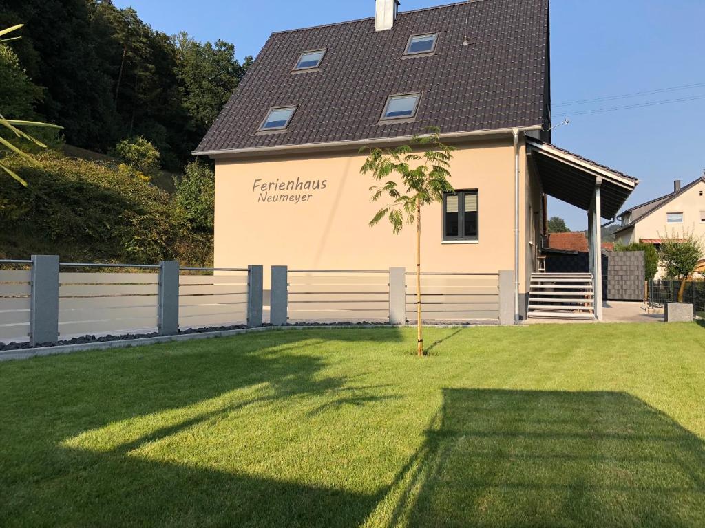 una casa con una valla y un patio de césped en Ferienhaus Neumeyer en Schönau