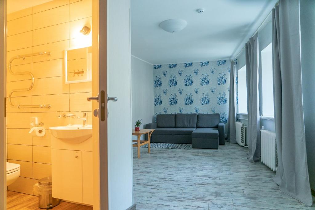 a bathroom with a couch and a sink in a room at Godart Rooms Guesthouse in Tallinn