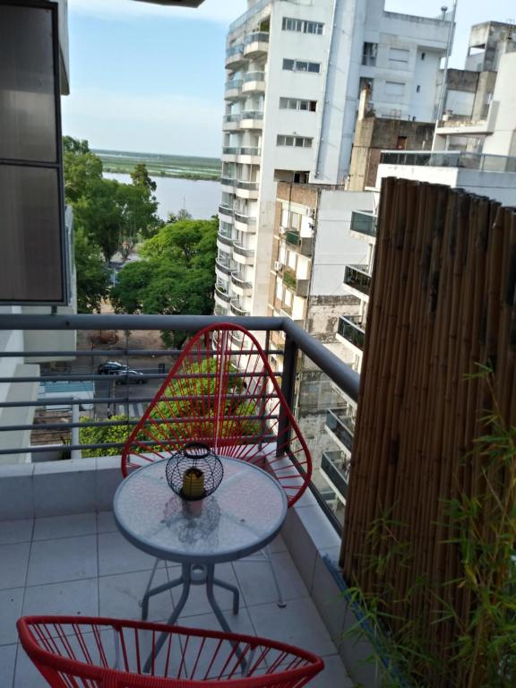 a table and chairs on a balcony with a view at Río Arriba in Rosario