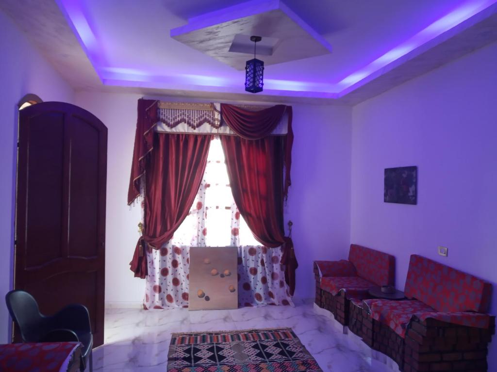 a living room with a window and purple lighting at Memnoun house in Luxor