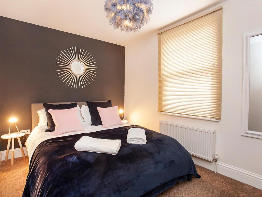 una camera con un grande letto e un lampadario a braccio di Apartment 5 Blue Bridge Court a York