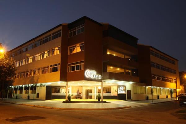 un grand bâtiment dans une rue la nuit dans l'établissement Hotel Le Park, à San Miguel de Tucumán