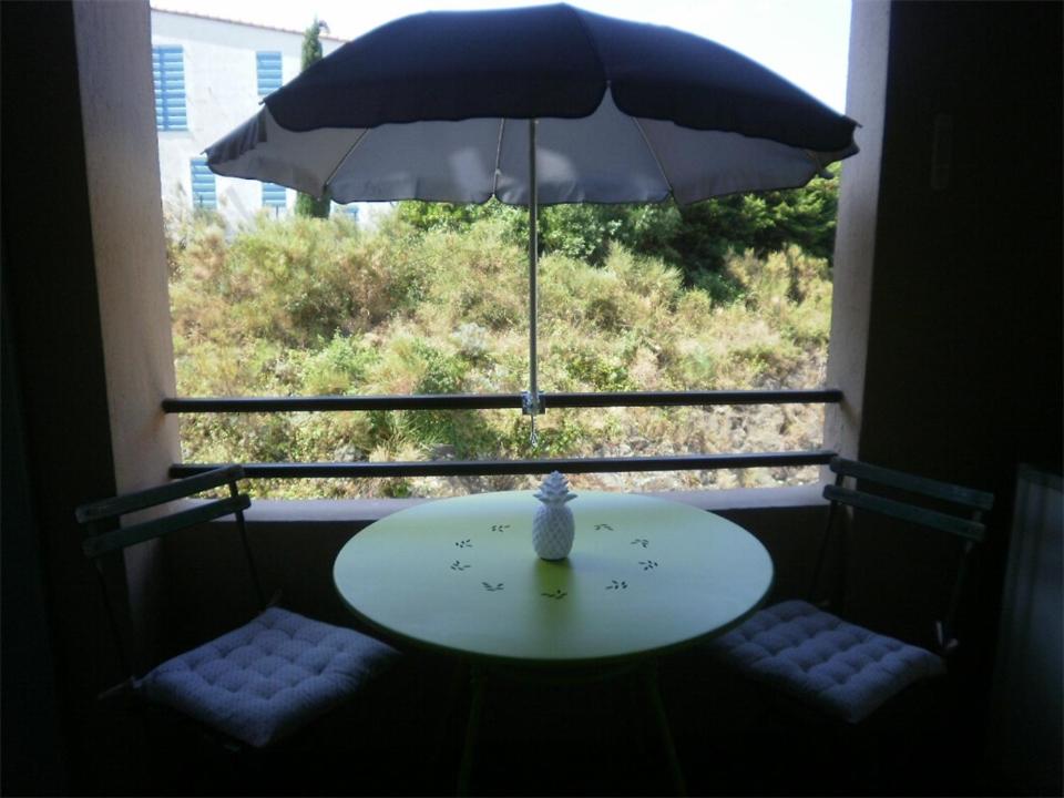 コリウールにある4PA44 appartement avec piscine et parkingの窓際の傘付きテーブル