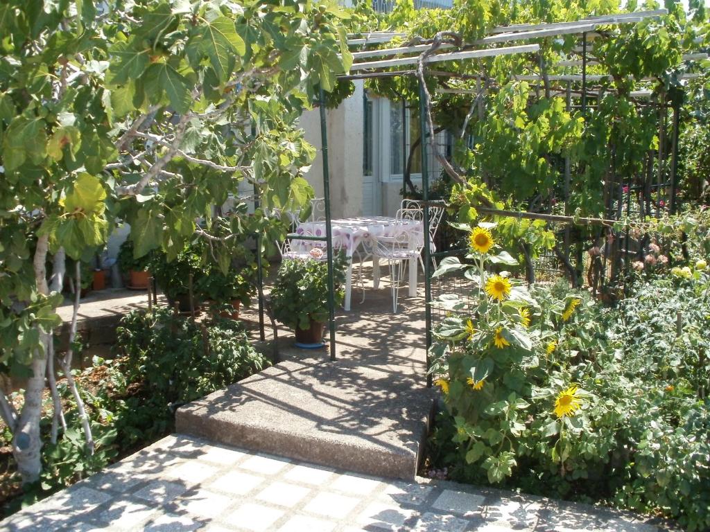 un jardin avec une table et des tournesols dans l'établissement Apartman Marija, à Senj