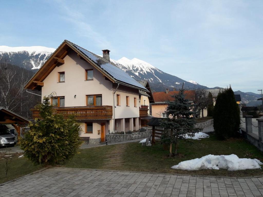 a house with a snow covered mountain in the background at apartma Marjetica in Blejska Dobrava