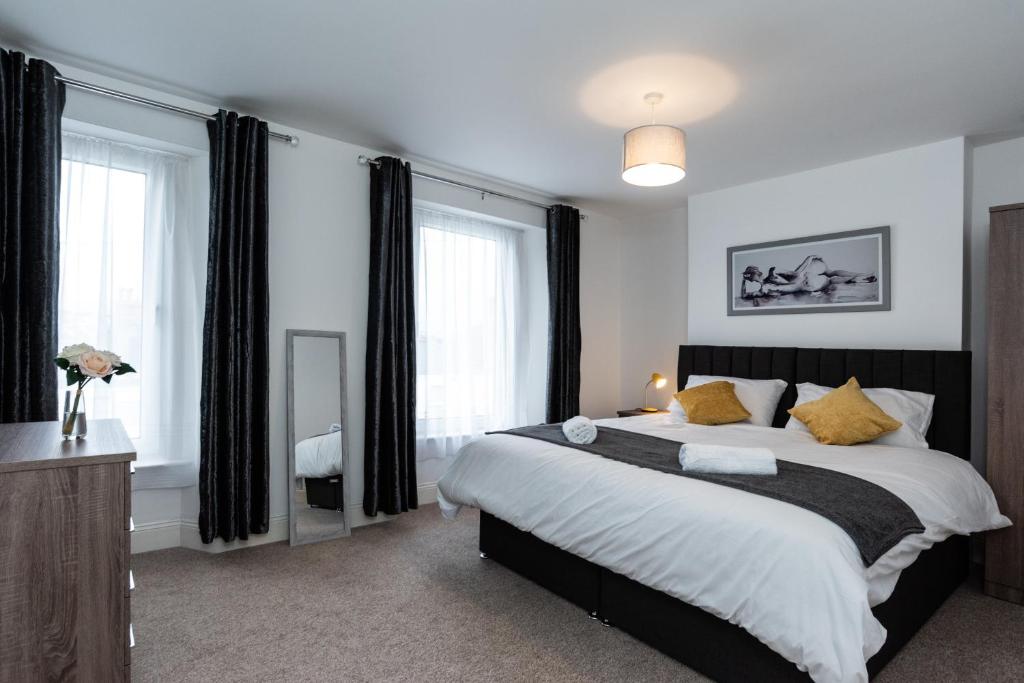 a bedroom with a large bed with yellow pillows at Milton House in Plymouth