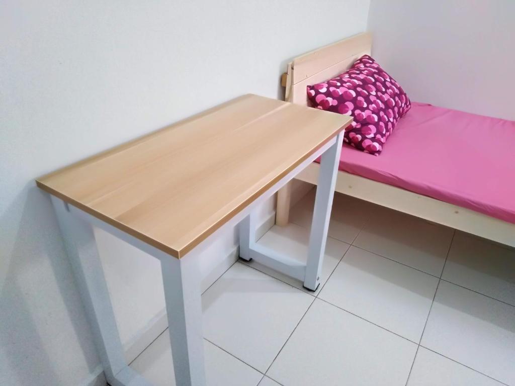 a bench with a pink cushion and a table at Jerantut Homestay 2 in Jerantut
