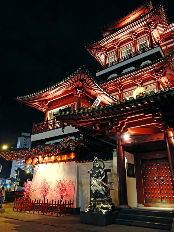 a building with a statue in front of it at night at Wink at Mosque Street in Singapore
