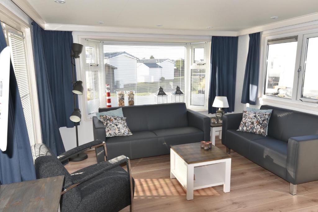 a living room with a couch and a table at Chalet Zeester J38 Ameland in Buren