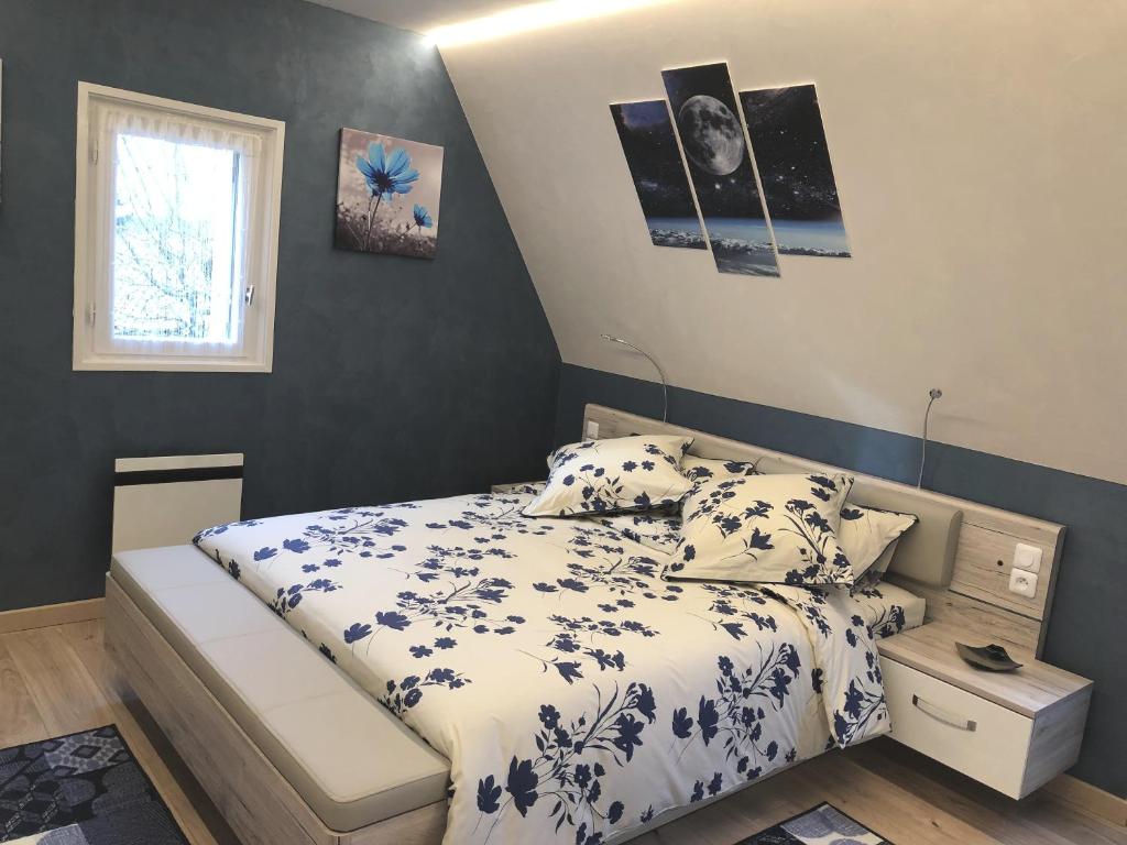 ein Schlafzimmer mit einem Bett mit blau-weißer Bettwäsche in der Unterkunft Chambre d'hôtes l'Olivianne in Sarlat-la-Canéda