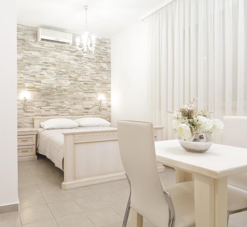 um quarto com uma cama e uma mesa com uma cadeira branca em Split Varos Inn em Split