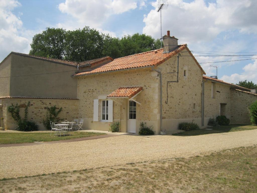 a large stone house with a gravel driveway at LA MAISON D'HENRI in Chauvigny